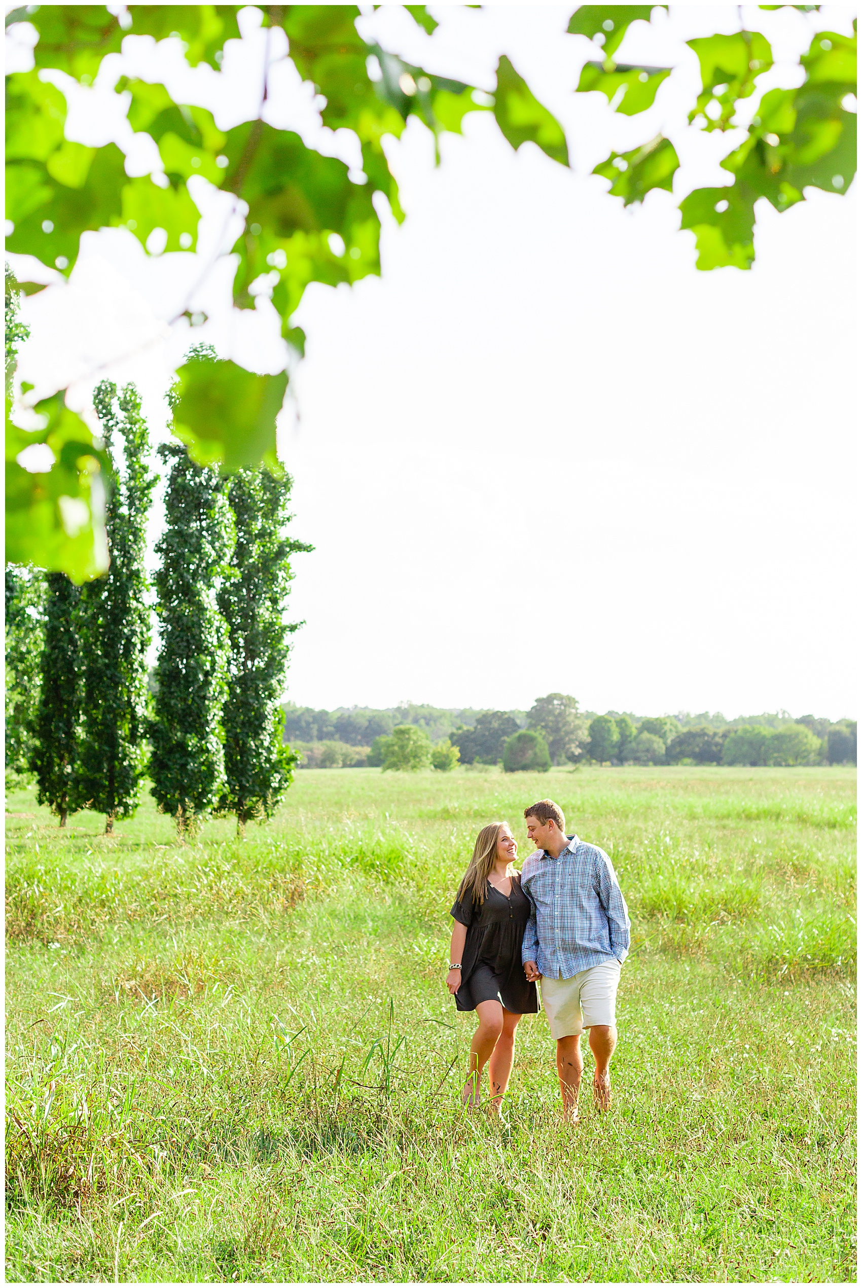 engaged couple walking in an open field
