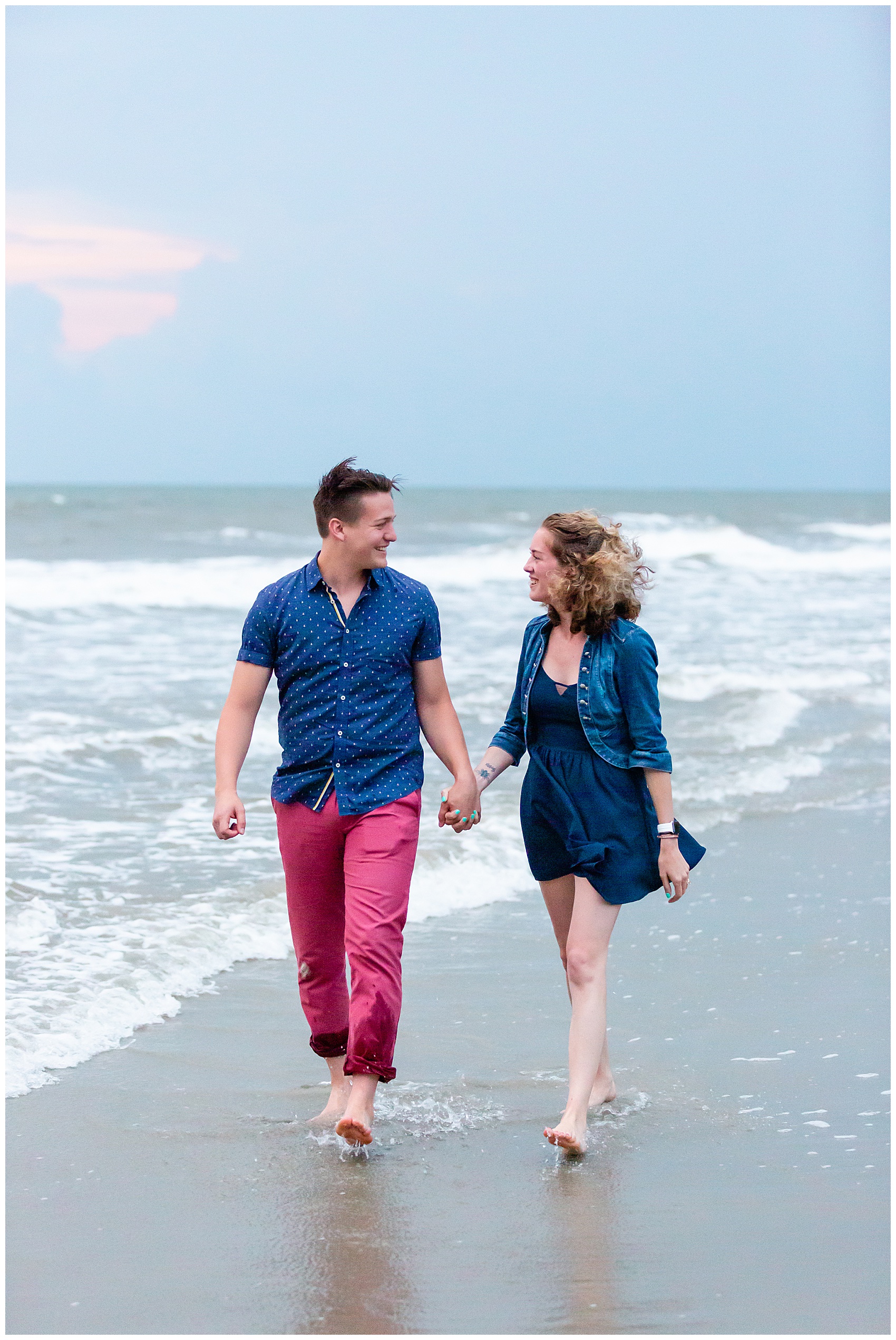 newly engaged couple walking on folly beach