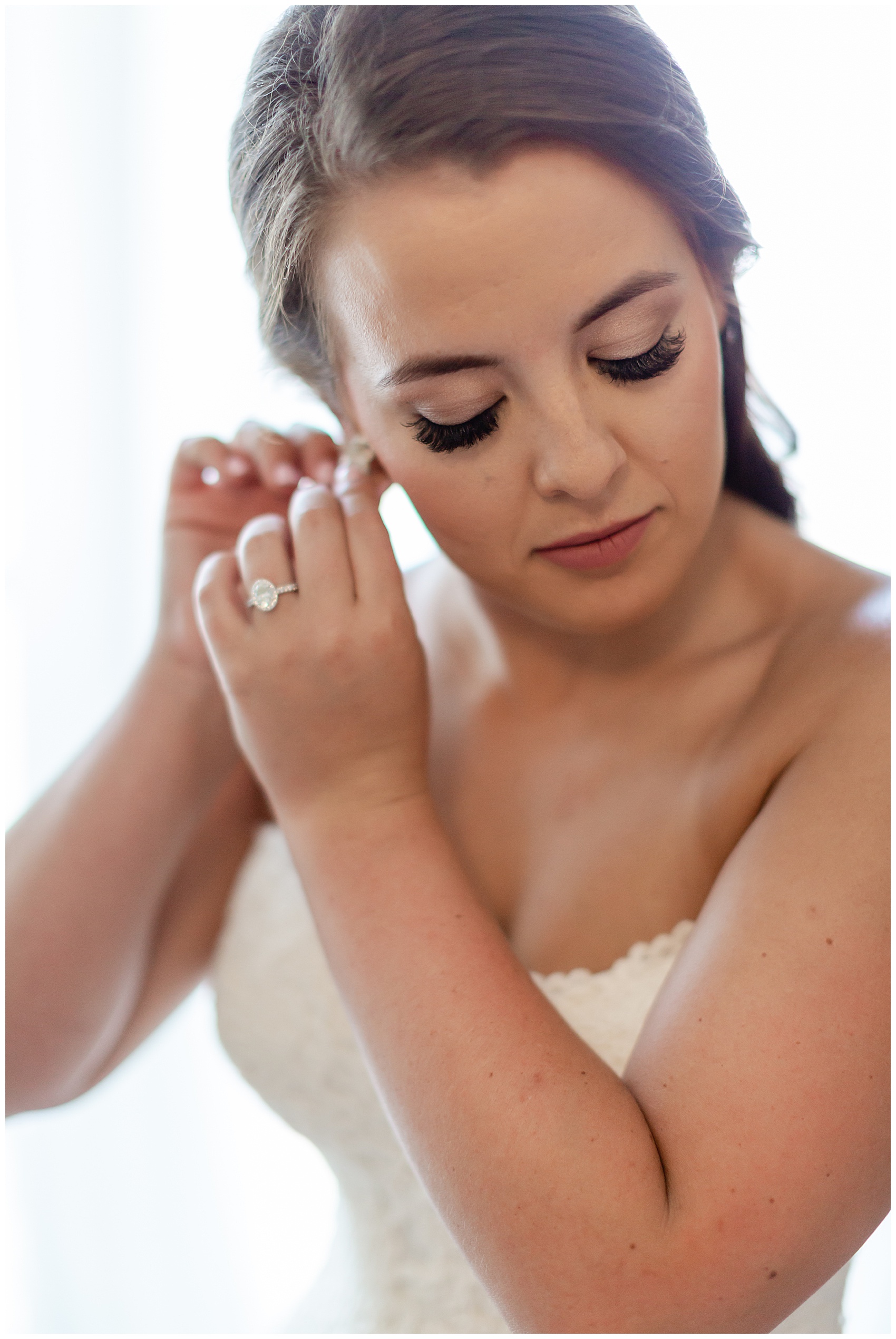bride putting on her earrings at the island house wedding in charleston south carolina 