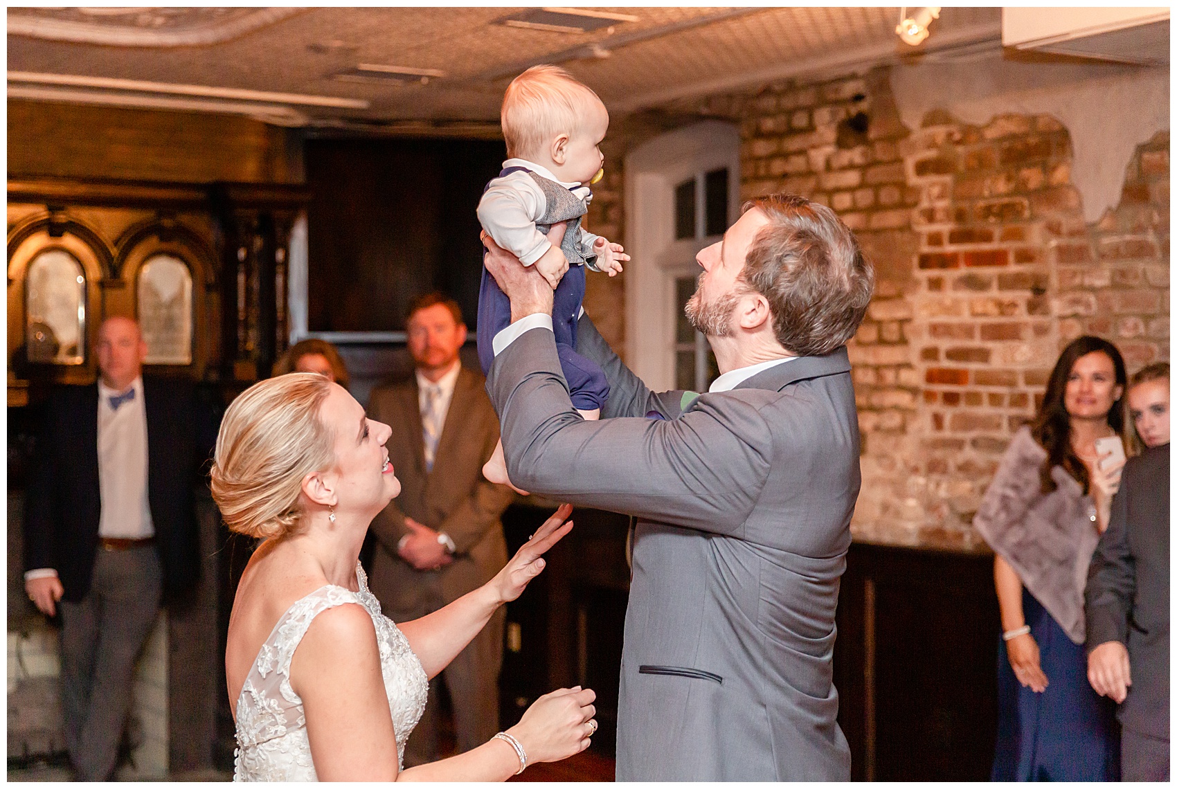 bride and groom take their little one for his first dance