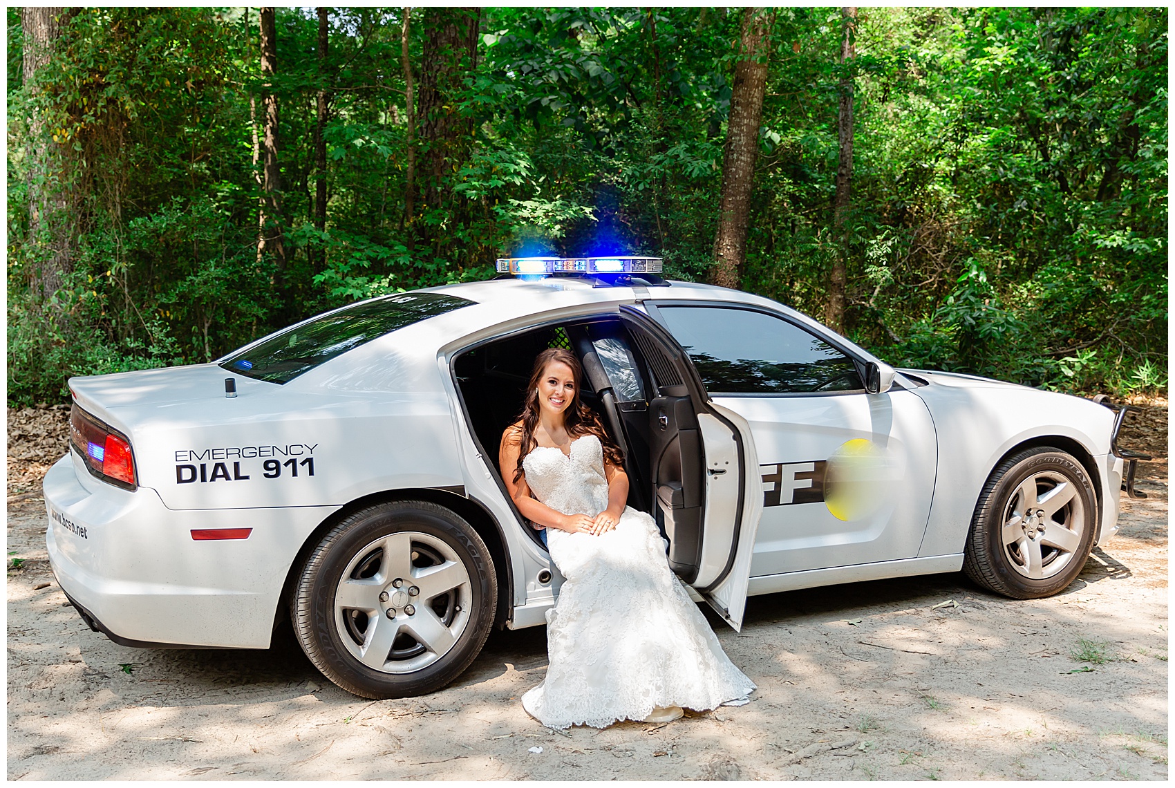 bride sitting in a cop car on her wedding day
